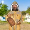 Commercial beekeeper wearing khaki ventilated bee suit during apiary work